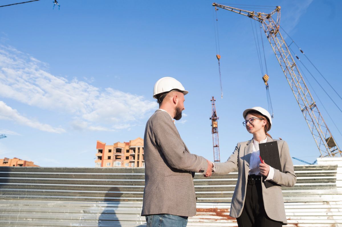 two-professional-engineer-shaking-hand-construction-site
